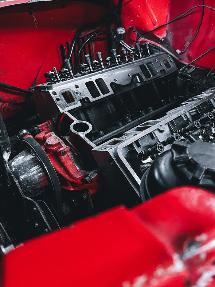 Services Detailed shot of a car engine within a vibrant red chassis, showcasing mechanical parts.